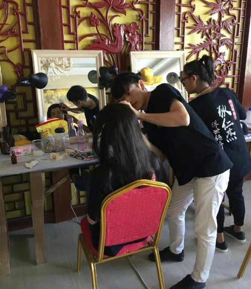 成远化妆学员郑智雄正在认真给《狄仁杰之浮世传奇》剧组演员化妆中